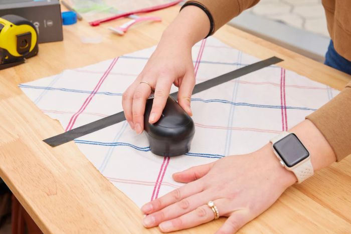 A person using the Magictec Rechargeable Fabric Shaver on a fabric surface