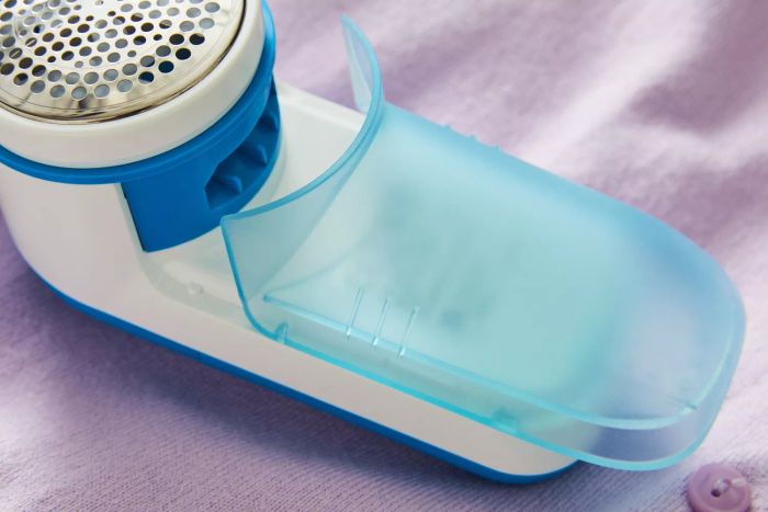The Philips GC026 Electric Lint Remover and Fabric Shaver displayed on a purple background