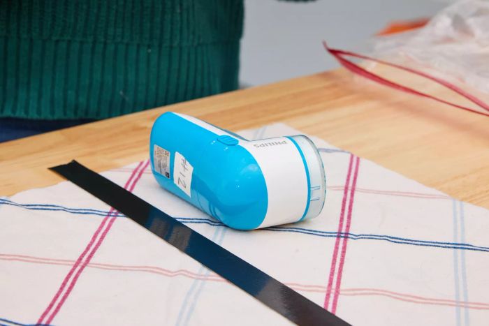 The Philips GC026 Electric Lint Remover and Fabric Shaver placed on a piece of fabric