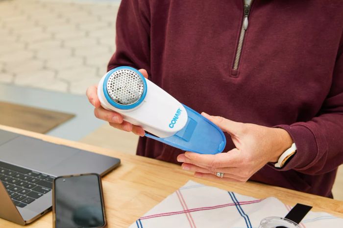 A pair of hands holding the Conair Fabric Shaver and Lint Remover