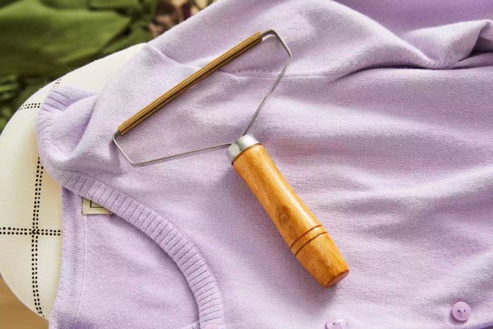 Ruri's Portable Lint Remover in use on a purple cardigan