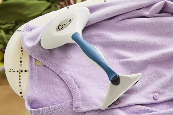 The Gleener Fabric Shaver & Lint Brush in action on a cardigan