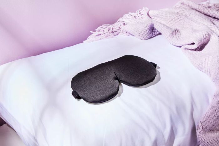Alaska Bear Silk Sleep Mask resting on a pillow.