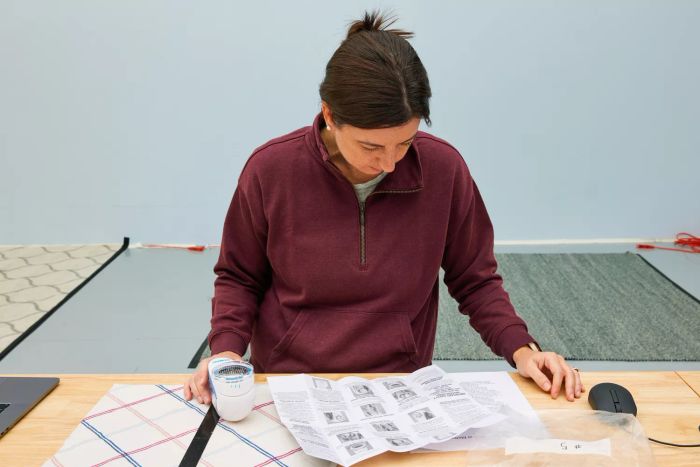A person reviewing the instruction manual for the Conair Fabric Shaver and Lint Remover