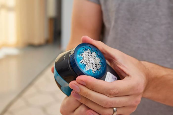 Two hands holding the Rowenta Portable Lint Remover Shaver with Adjustable Shave Height