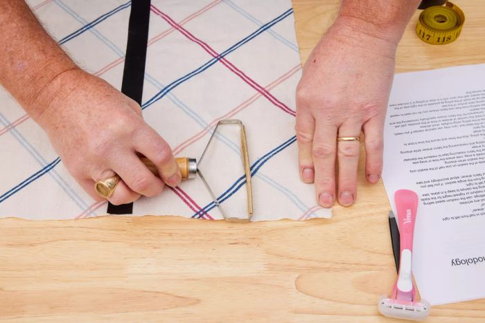 A person using Ruri's Portable Lint Remover on a fabric surface