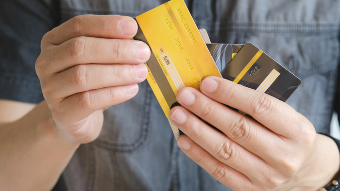 A person holding multiple credit cards in their hand
