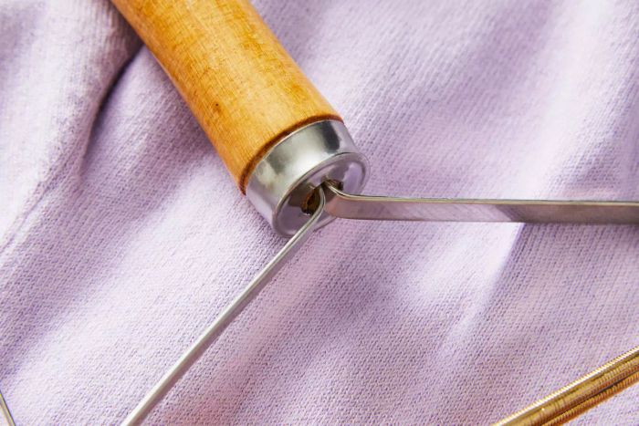 A detailed close-up of Ruri's Portable Lint Remover against a purple backdrop