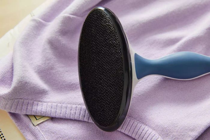 The Gleener Fabric Shaver & Lint Brush in use on a sweater