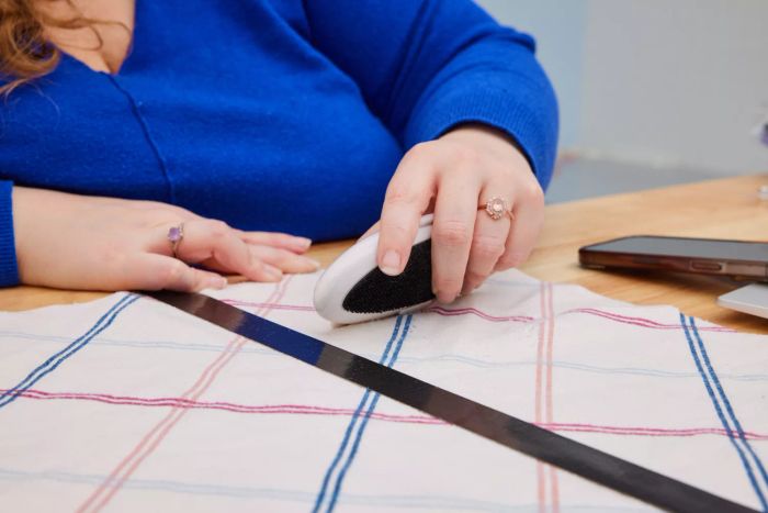 A person using the Gleener On The Go Portable Compact Fabric Shaver & Lint Remover