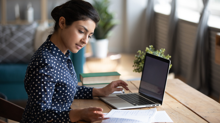 A woman concentrating on her laptop while working.