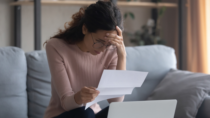 A woman overwhelmed while reviewing documents.