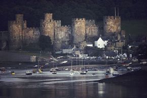 Boats float on the water in front of Conway Castle.