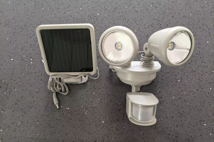 Maxsa Motion-Activated Dual Head Solar Security Light components laid out on a grey surface