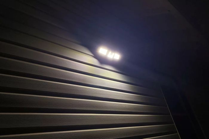 Ameritop Outdoor Mounting Solar Lights installed on the side of a house and illuminated at night