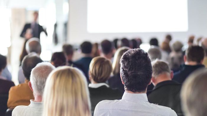 Individuals attending a conference presentation