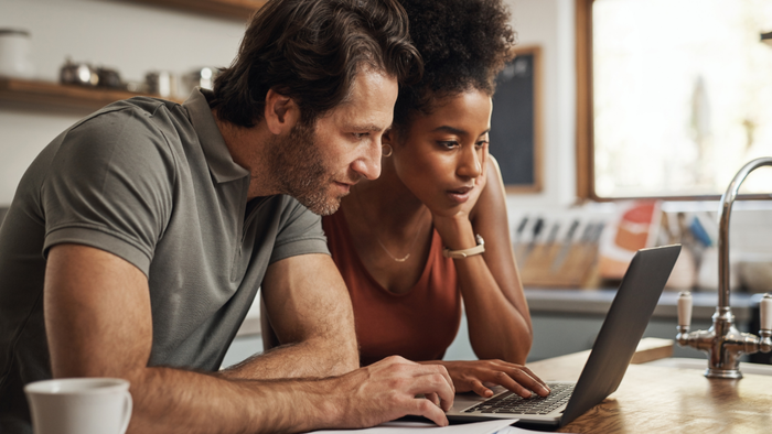 A couple exploring information on a laptop together.