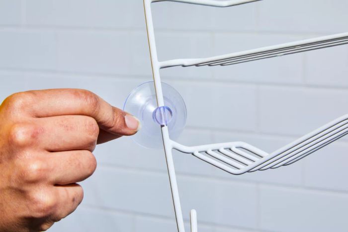 A person adjusting the suction cup on the Zenna Home Shower Caddy