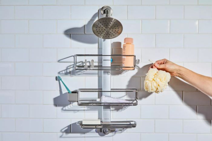 Someone placing a loofah onto the simplehuman Shower Caddy