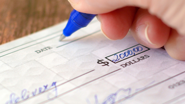 A close-up of someone filling out a personal check