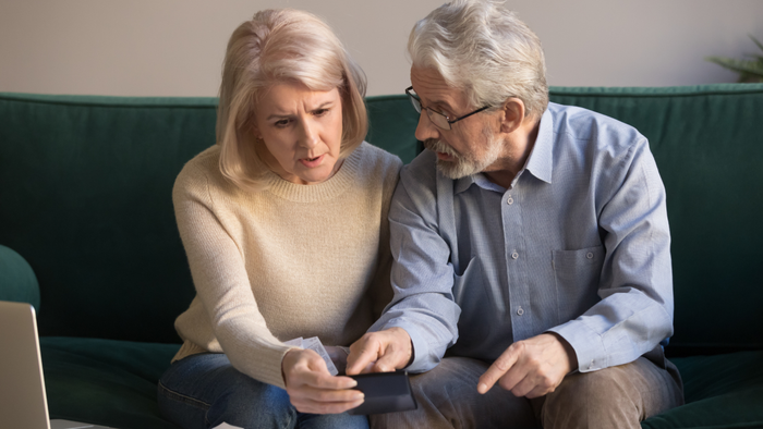 An anxious elderly couple reviewing documents