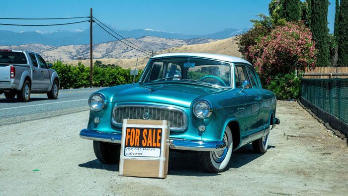 A classic car with a 'For Sale' sign