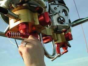 A hand adjusts the propane valve.