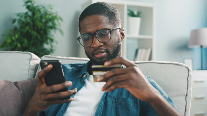 Person reviewing their phone and credit card.