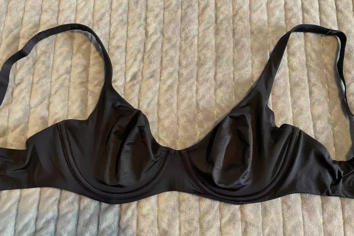 A black Cuup The Scoop Bra laid out on a blanket