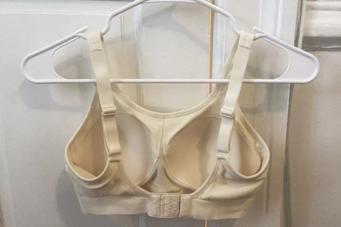 True & Co. Soft Form V Neck Adjustable Strap Bra hanging on a hanger