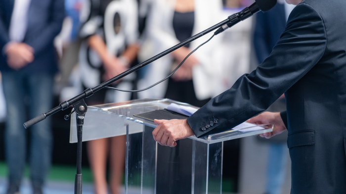 A political rally featuring a candidate speaking to a crowd of supporters.
