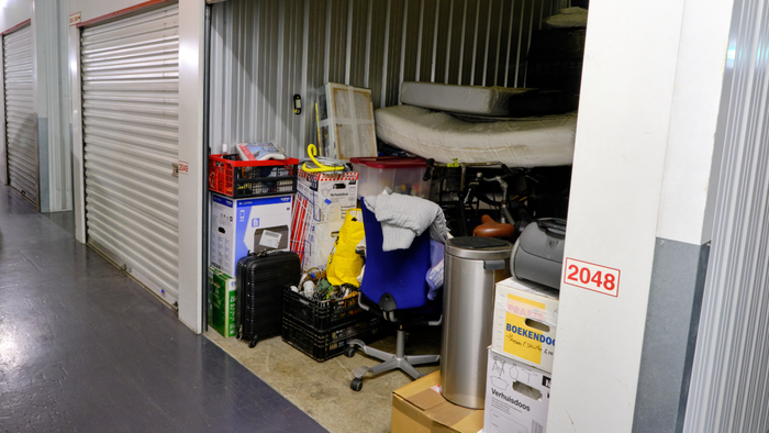 a storage unit with its door open, revealing various items inside