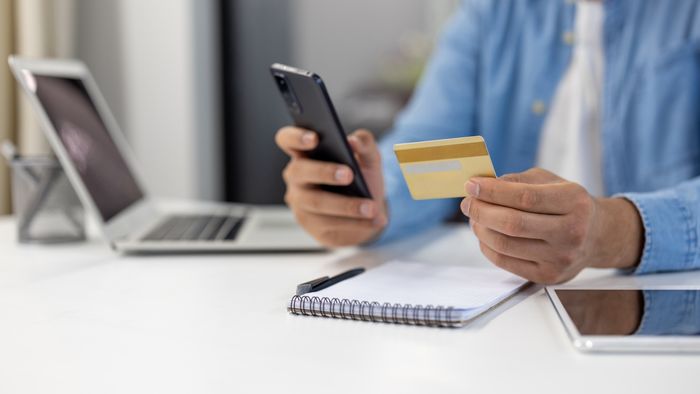 A person enters credit card details into their phone.