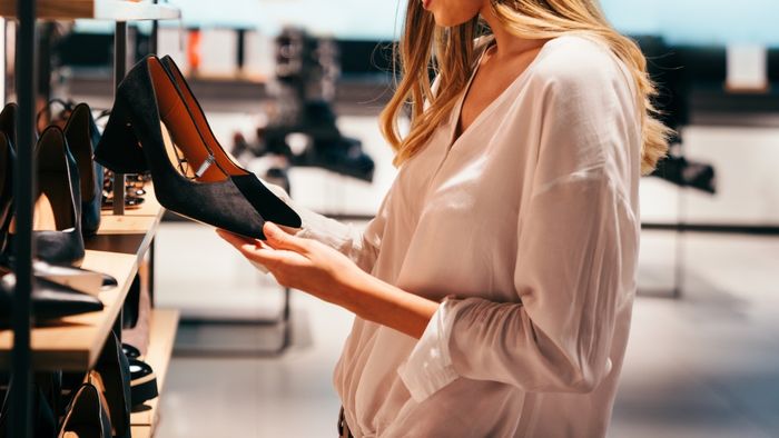 A woman browsing for shoes at a retail store
