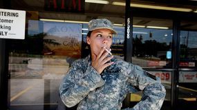 A soldier lighting up a cigarette.