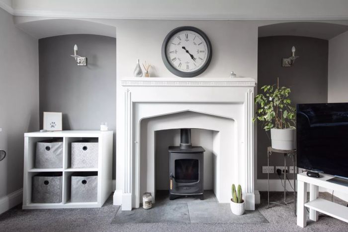 An interior shot showcasing a white and gray-themed lounge with a wood burner fireplace.