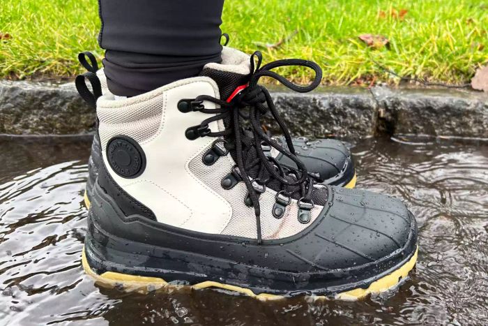 An individual sporting the Hunter Women's Explorer Duck Boots while standing in water outdoors
