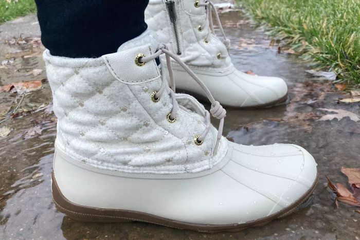 A person wearing the Sperry Women’s Syren Gulf Duck Boot while standing in water