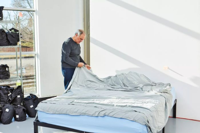 A person arranging the Slumber Cloud Essential Duvet Cover on a bed