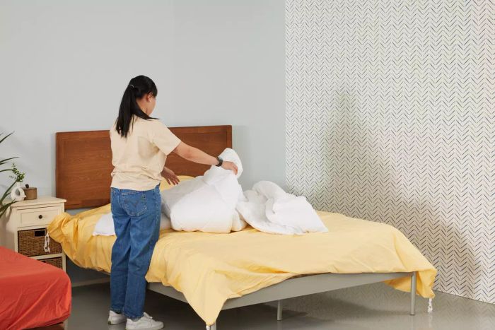 A person neatly folding a L.L.Bean 280-Thread-Count Pima Cotton Percale Comforter Cover
