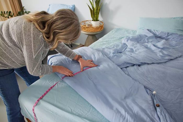 A person taking measurements of the Sijo AiryWeight Eucalyptus Duvet Cover