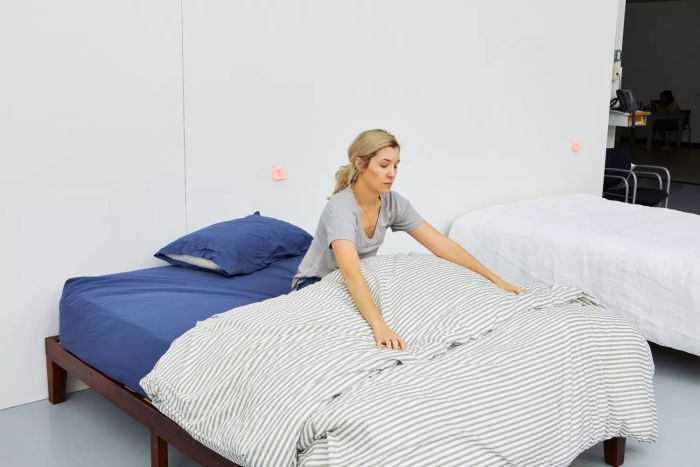 A person seated on a bed adorned with a Jellymoni 100% Natural Cotton Duvet Cover