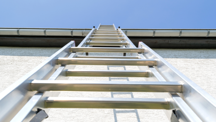 image of a ladder leaning against a house viewed from below