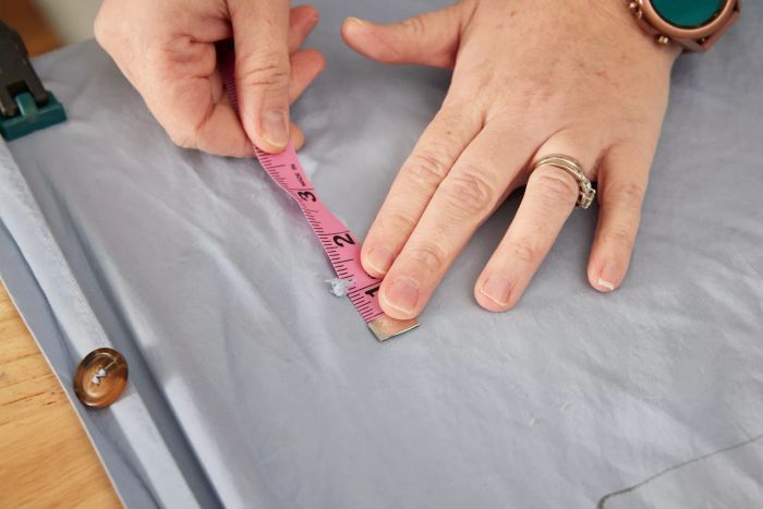 A person measuring a tear in the Sijo AiryWeight Eucalyptus Duvet Cover