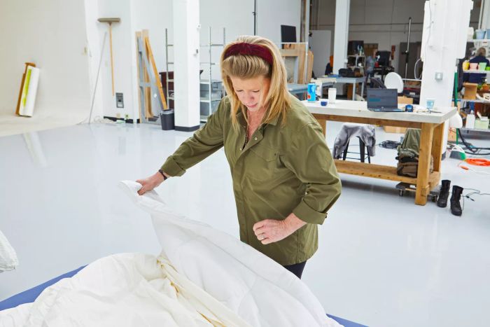 An individual adjusting the duvet inside The Company Store's Cotton Rayon Bamboo Sateen Duvet Cover