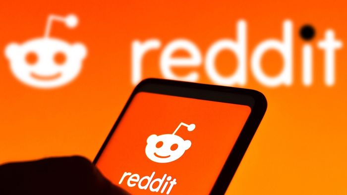 A smartphone and monitor displaying the Reddit logo