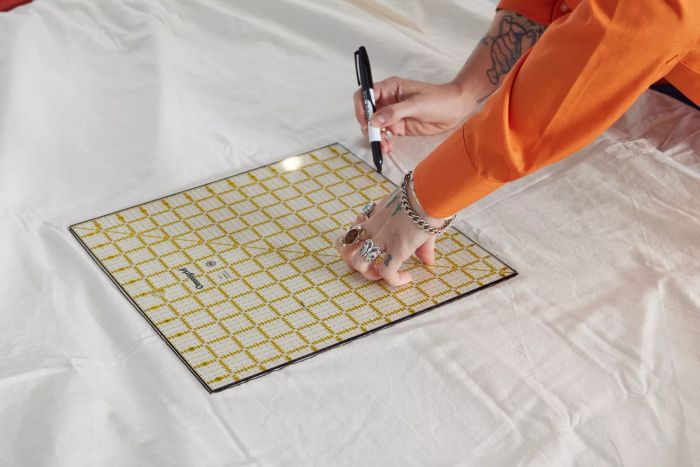 A person marking a square on the Southern Living Simplicity Collection Tanner Duvet Cover.