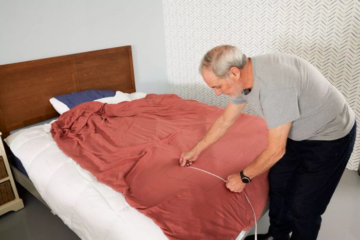 A person testing a Sunday Citizen Natural Premium Bamboo Duvet Cover on a bed