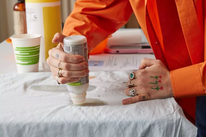 A person conducting a stain test on the Riley Percale Duvet Cover.