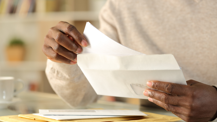 A close-up of hands unsealing an envelope